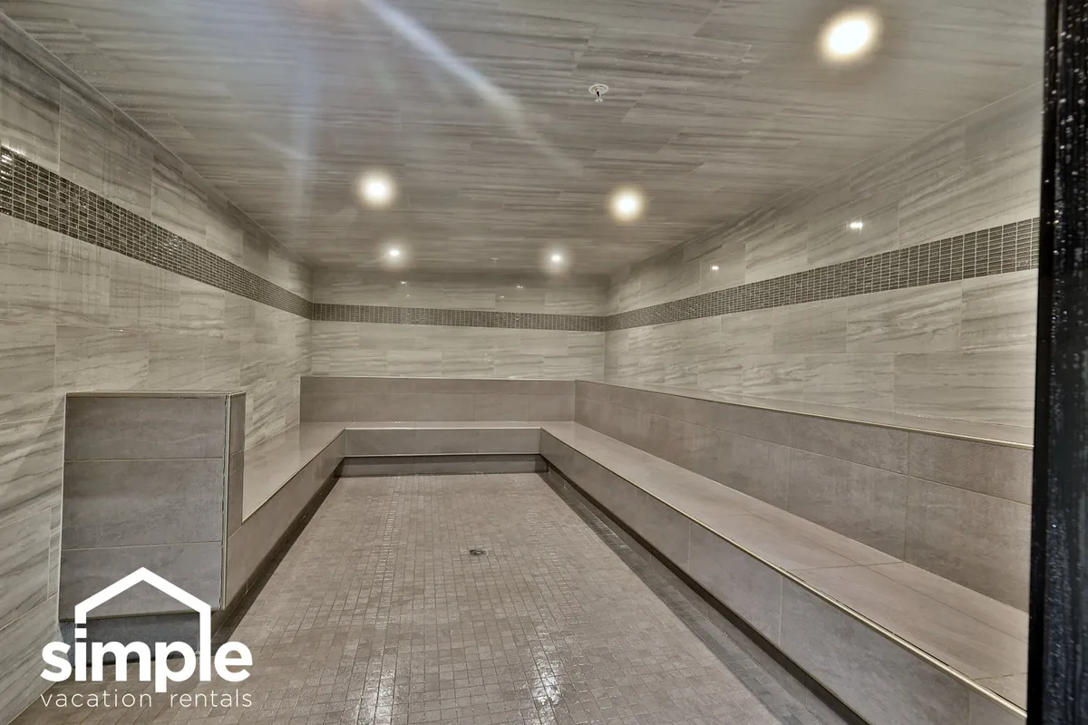 A modern and serene indoor wellness area with spacious seating, smooth tiles, and ambient lighting. The space is designed for relaxation and socializing, suggesting a tranquil retreat for post-activity recovery.